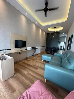 a living room with a blue couch and a ceiling fan at Adik aisyah Cameron Black Pink in Tanah Rata