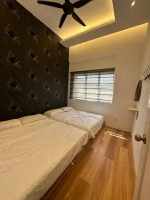 a bedroom with two beds and a ceiling fan at Adik aisyah Cameron Black Pink in Tanah Rata