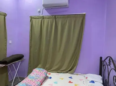 a bedroom with a bed with a green curtain at Sekinchan Homestay Teratak AZ - muslm only in Kampong Batu Dua Puloh Tiga