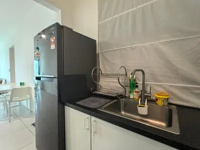 a kitchen with a sink and a refrigerator at Meritus Comfy 3 Bedroom with 8 Pax in Jalan Baharu