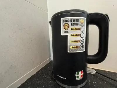 a black cup with stickers on it next to a wall at Meritus Comfy 3 Bedroom with 8 Pax in Jalan Baharu