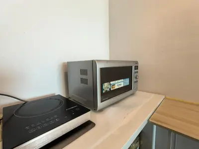 a microwave sitting on top of a counter with a printer at Meritus Comfy 3 Bedroom with 8 Pax in Jalan Baharu