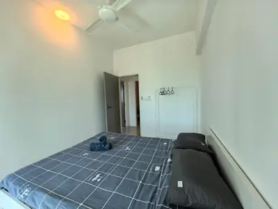 a bed in a room with a ceiling fan at Meritus Comfy 3 Bedroom with 8 Pax in Jalan Baharu