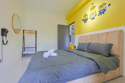 a bedroom with a large bed with a yellow wall at Minion Escap Family Homestay in Brinchang Cameron Highland Clover Home 9-25 in Brinchang