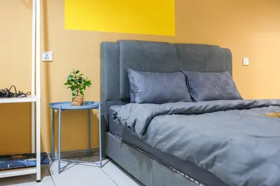a bed in a room with a yellow wall at Cozy Premium Family Homestay in Cameron Highlands Brinchang Clover Home 4-06 in Brinchang