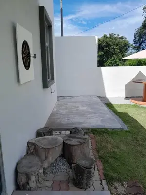 a patio with three logs in front of a building at SimpleHome in Tupai