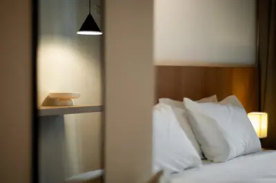 a bedroom with a bed with white pillows and a mirror at Heritage Villa by Aayu - 10 mins walk to Armenian St in George Town
