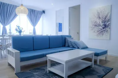 a living room with a blue couch and a table at Tung's Hideout- Centrum Cameron in Brinchang