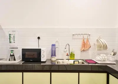 a kitchen counter with a microwave and a sink at Ipoh South Homestay 8-16pax 10mins to attraction in Ipoh