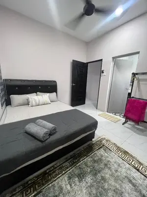 a bedroom with a large bed and a red chair at D'Nuha homestay Unit 2 Chenderong Balai Teluk Intan in Kampung Degong