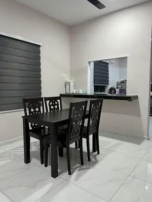 a black dining room table and chairs in a kitchen at D'Nuha homestay Unit 2 Chenderong Balai Teluk Intan in Kampung Degong