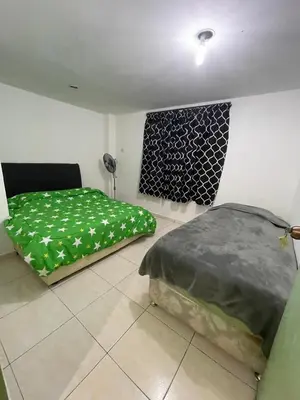 two beds in a room with green sheets at INAP DESA ANTHURIUM CAMERON HiGHLANDS in Tanah Rata