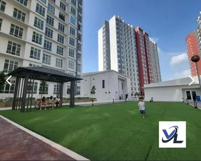 a young boy standing in a field of grass in front of a building at Close Dun Book in Ipoh
