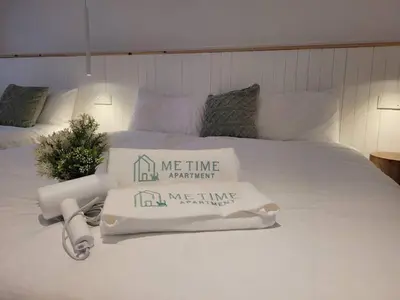 a white bed with two pillows on top of it at Metime Ipoh Garden in Ipoh