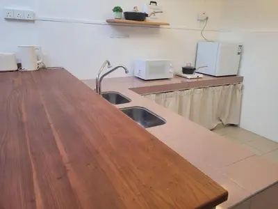 a kitchen with a wooden counter top with a sink at Metime Ipoh Garden in Ipoh
