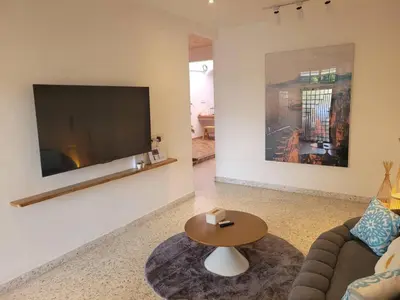 a living room with a couch and a table and a tv at Metime Ipoh Garden in Ipoh