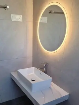 a white sink in a bathroom with a round mirror at Metime Ipoh Garden in Ipoh