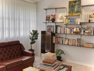 a living room with a couch and books at The Petrichor in Tupai