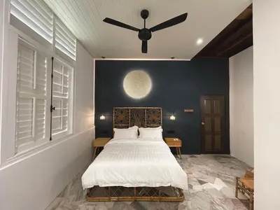 a bedroom with a bed and a ceiling fan at The Petrichor in Tupai