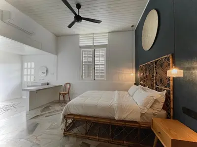 a bedroom with a bed and a ceiling fan at The Petrichor in Tupai