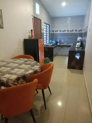 a kitchen with a table and orange chairs in a room at Ipoh Buntong Corner homestay in Ipoh