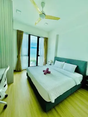 a bedroom with a large bed with a teddy bear on it at Jazz Service Suite in Bagan Jermal