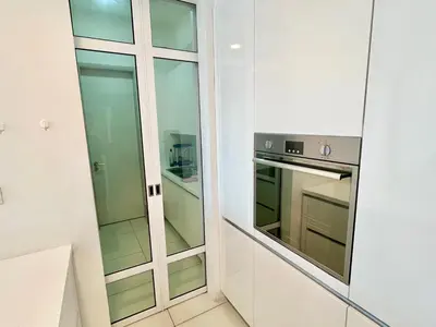 a kitchen with white cabinets and an oven at Jazz Service Suite in Bagan Jermal