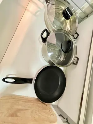 four pots and pans hanging on a kitchen wall at Jazz Service Suite in Bagan Jermal