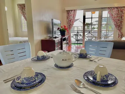 a table with a teapot and plates on it at Cozy Cottage-Style Apartment Entire Unit in Tanah Rata