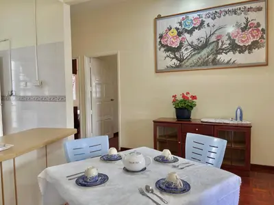 a dining room with a table and a kitchen at Cozy Cottage-Style Apartment Entire Unit in Tanah Rata