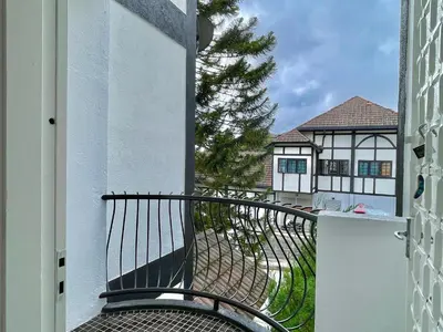 an open door to a balcony with a view of a house at Cozy Cottage-Style Apartment Entire Unit in Tanah Rata