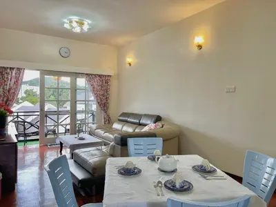 a living room with a table and a couch at Cozy Cottage-Style Apartment Entire Unit in Tanah Rata