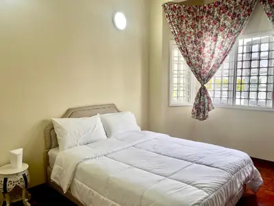 a bedroom with a white bed with a window at Cozy Cottage-Style Apartment Entire Unit in Tanah Rata