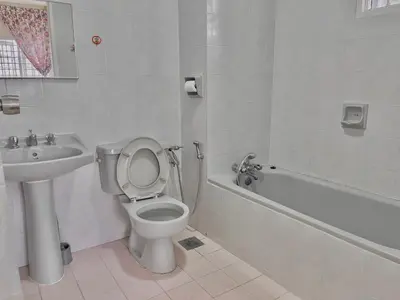 a white bathroom with a toilet and a sink at Cozy Cottage-Style Apartment Entire Unit in Tanah Rata