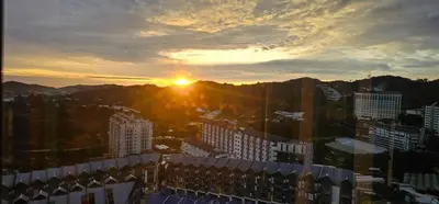 a sunset over a city with tall buildings at Cameron Palas Homestay - Sunrise View in Brinchang
