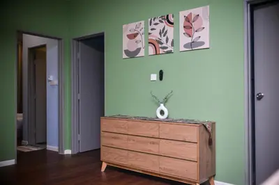 a room with a dresser and paintings on the wall at Cameron Palas Homestay - Sunrise View in Brinchang