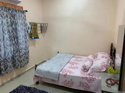 a bedroom with a bed with pink and white sheets at Teratak Annur Homestay in Tanjung Karang