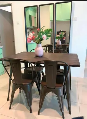 a wooden table with chairs and a vase with flowers on it at O Homestay Meru Ipoh at Casa Kayangan - Musleem in Bandar Meru Raya