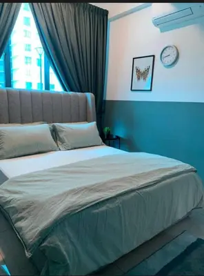 a bedroom with a large bed with a clock on the wall at O Homestay Meru Ipoh at Casa Kayangan - Musleem in Bandar Meru Raya