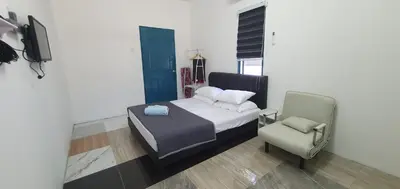 a bedroom with a bed and a chair at Chalet Meroloh Kuala Kangsar in Kuala Kangsar