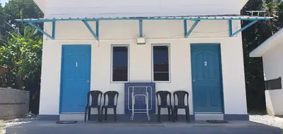 four chairs in front of a house with blue doors at Chalet Meroloh Kuala Kangsar in Kuala Kangsar