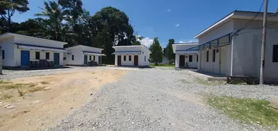 a row of white buildings on a dirt road at Chalet Meroloh Kuala Kangsar in Kuala Kangsar