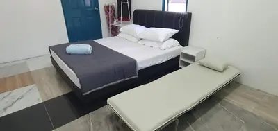 a bedroom with two beds and a bench in it at Chalet Meroloh Kuala Kangsar in Kuala Kangsar