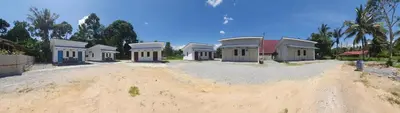 a row of houses sitting on top of a dirt road at Chalet Meroloh Kuala Kangsar in Kuala Kangsar