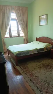 a bedroom with a bed and a window and a rug at Will Ma in Ayer Itam