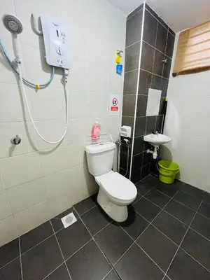 a bathroom with a shower and a toilet and a sink at Khasif Amani Homestay Parit Buntar in Parit Buntar