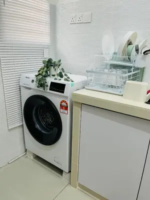 a washing machine in a kitchen next to a counter at Khasif Amani Homestay Parit Buntar in Parit Buntar