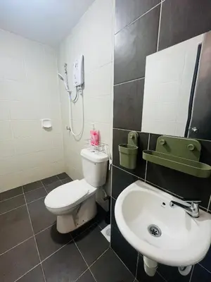 a bathroom with a white toilet and a sink at Khasif Amani Homestay Parit Buntar in Parit Buntar