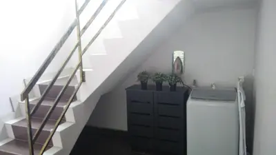 a staircase with a chest of drawers and a white stair railing at Bercham Vacation House in Ipoh