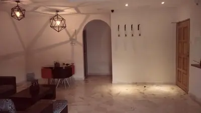 a living room with a table and lights on the wall at Bercham Vacation House in Ipoh